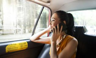 Woman in taxi on mobile phone